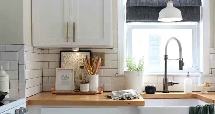 cocina moderna con una encimera de madera y artefactos de metal