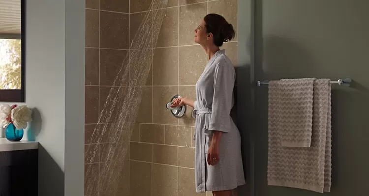 Mujer en bata de baño abriendo la ducha